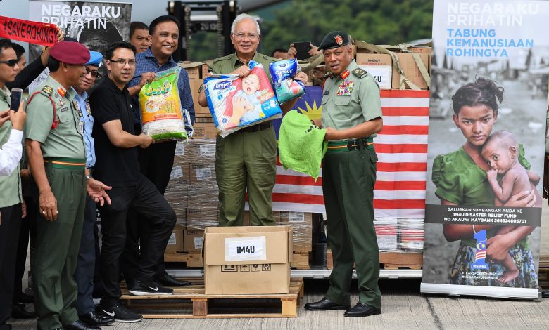 1267621 رئيس وزراء ماليزيا يحمل عينات من المساعدات الإنسانية للروهينجا1712345104